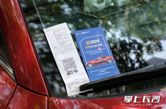 智能车位的管理人员将打印二维码和宣传卡放置在车辆上，引导车主支付。